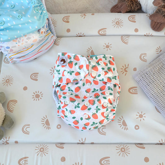 Pick Your Own strawberry cloth nappy on a changing mat