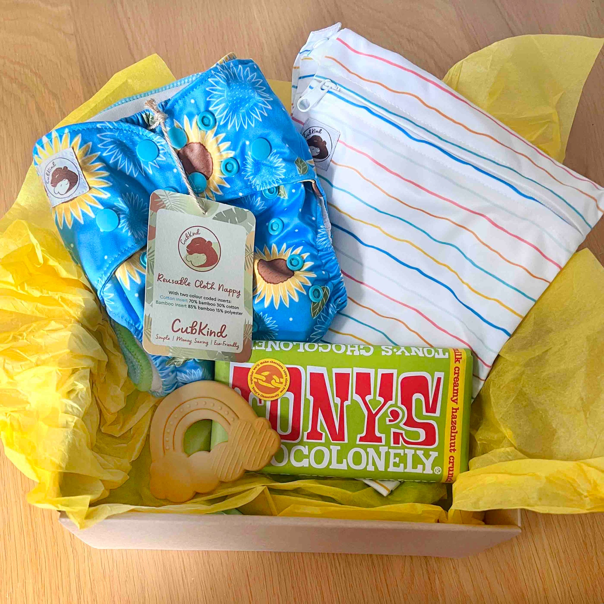 new to cloth gift set containing a reusable nappy, small wetbag, teether and chocolate
