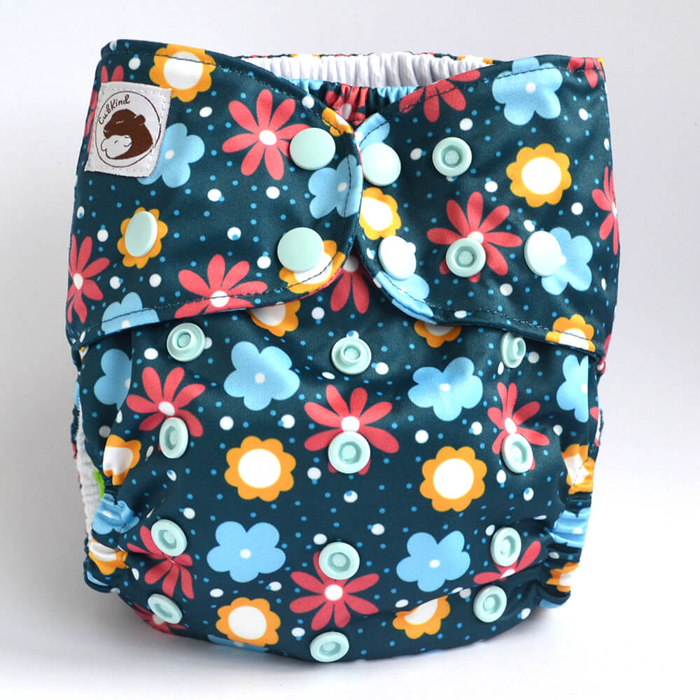 A dark blue cloth nappy with blue, yellow and pink flower design.