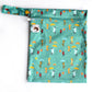 A small wetbag which is green with cats and dogs holding umbrellas. 
