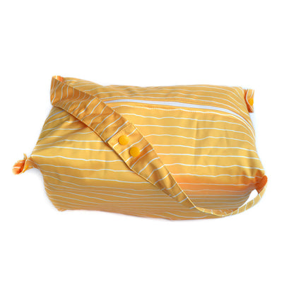 A yellow nappy pod with white stripes. The handles have been poppered together to create one long handle.